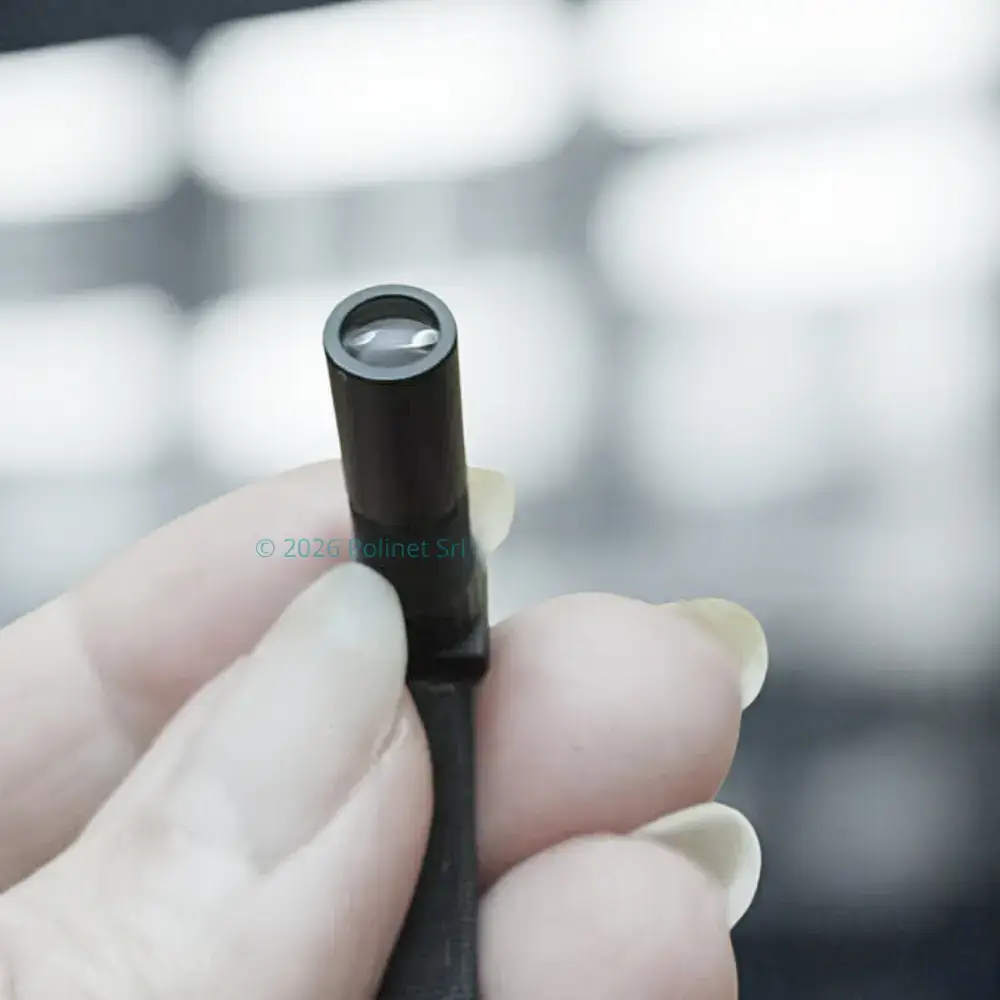 Microcamera professionale Polinet Srl per lettura targhe tenuta tra le dita per mostrarne le dimensioni miniaturizzate.